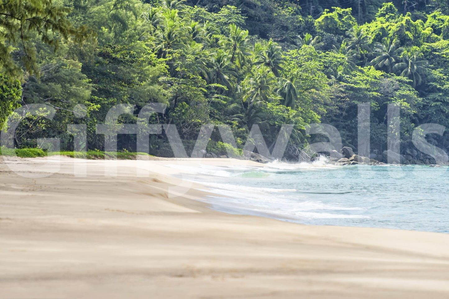 Beach Haven wall mural shown full-wall: a quiet sandy beach meeting turquoise waves below a dense green jungle