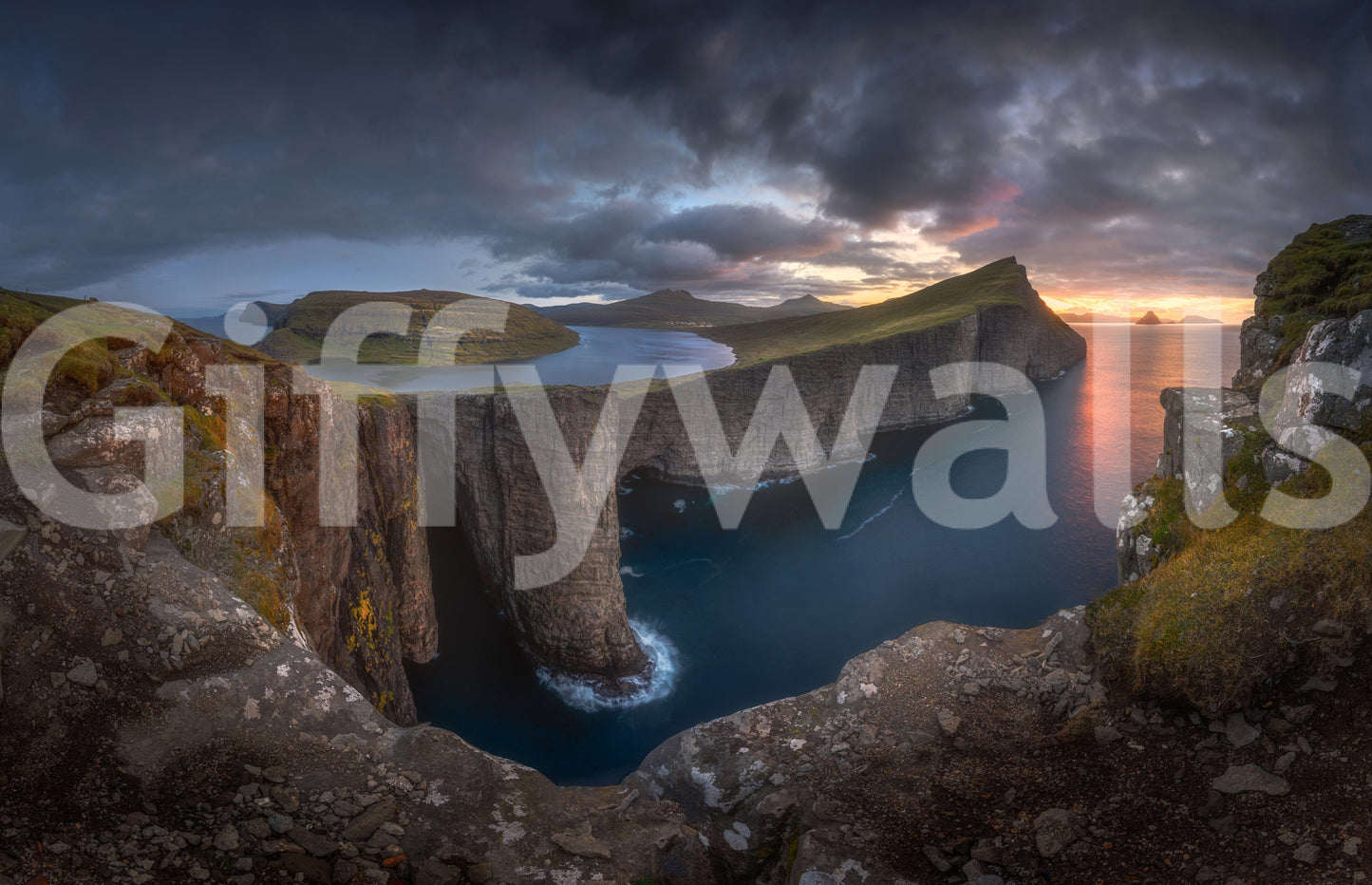 Faroe Cliffs Dawn wallpaper mural close-up of the lake-above-ocean cliffs under a stormy orange sunset sky