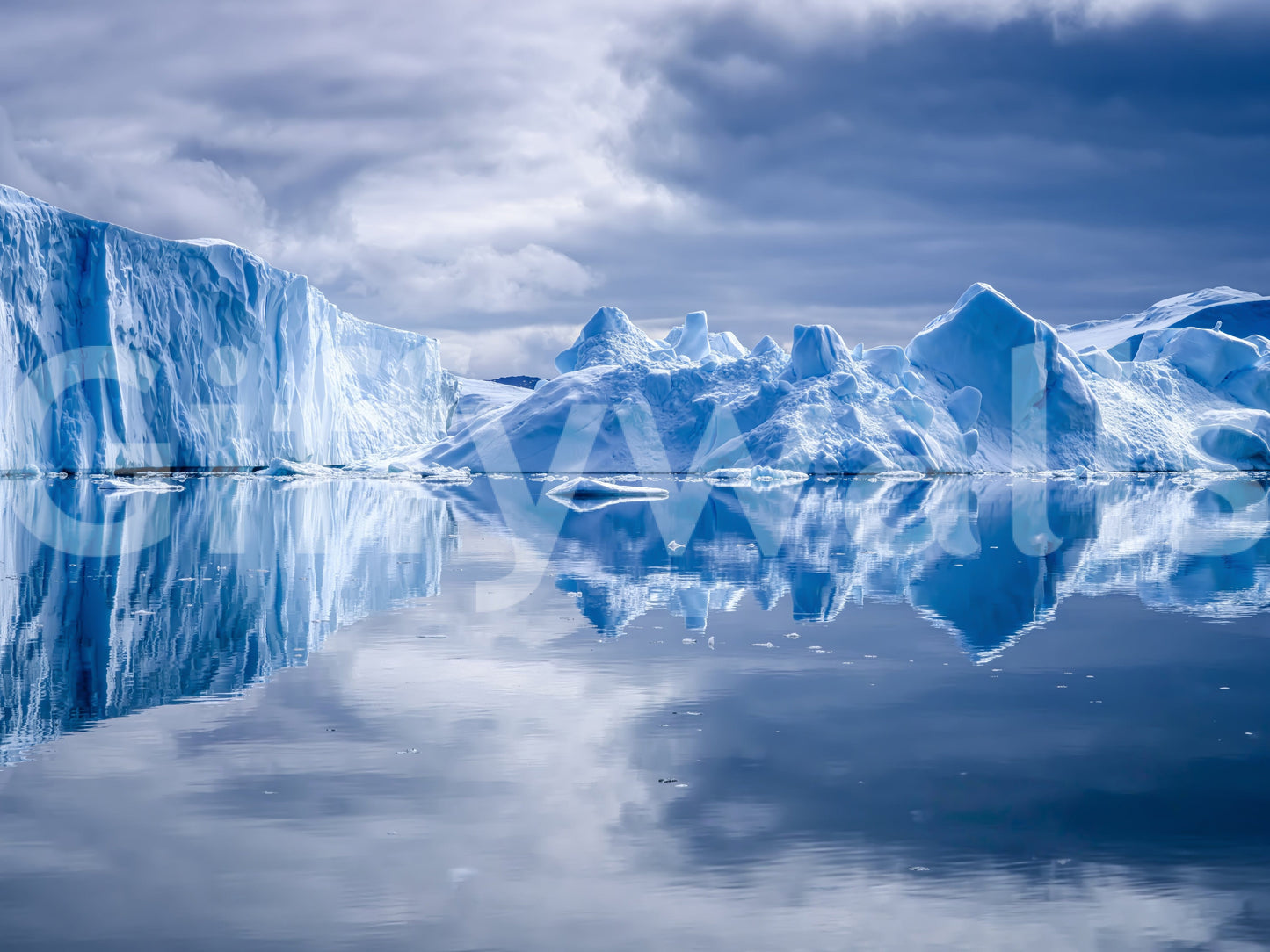 Frozen Dreams wallpaper mural close-up of blue icebergs mirrored in calm water under a soft cloudy sky