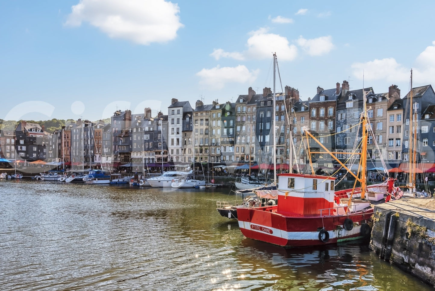 Honfleur Harbor Charm wallpaper mural shown as a full-wall view of the harbor, townhouses and red fishing boat