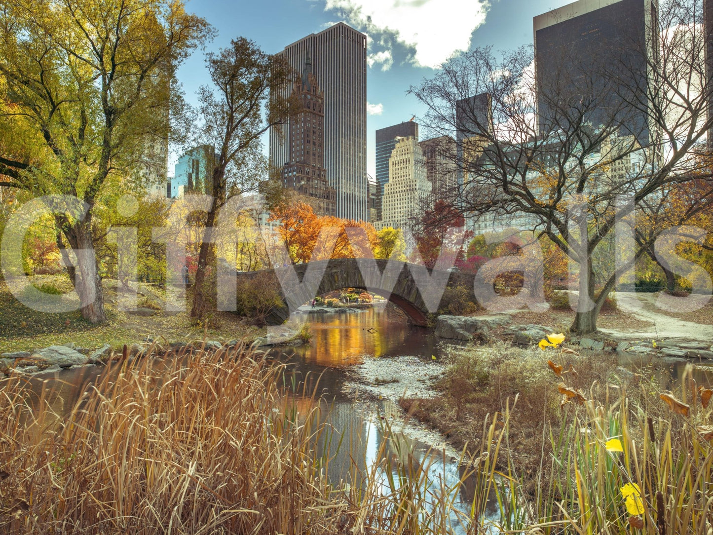 Manhattan's Autumn Embrace wallpaper mural shown as a full-wall view of Central Park's bridge and the fall skyline