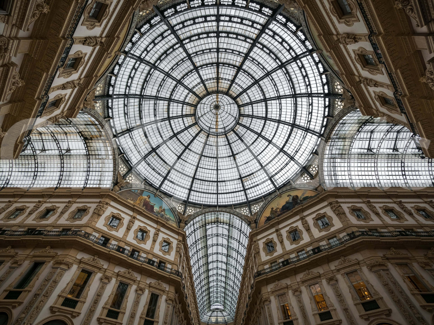 Milan Dome Majesty wallpaper mural shown full-wall, looking up at the ornate glass and iron domed gallery ceiling