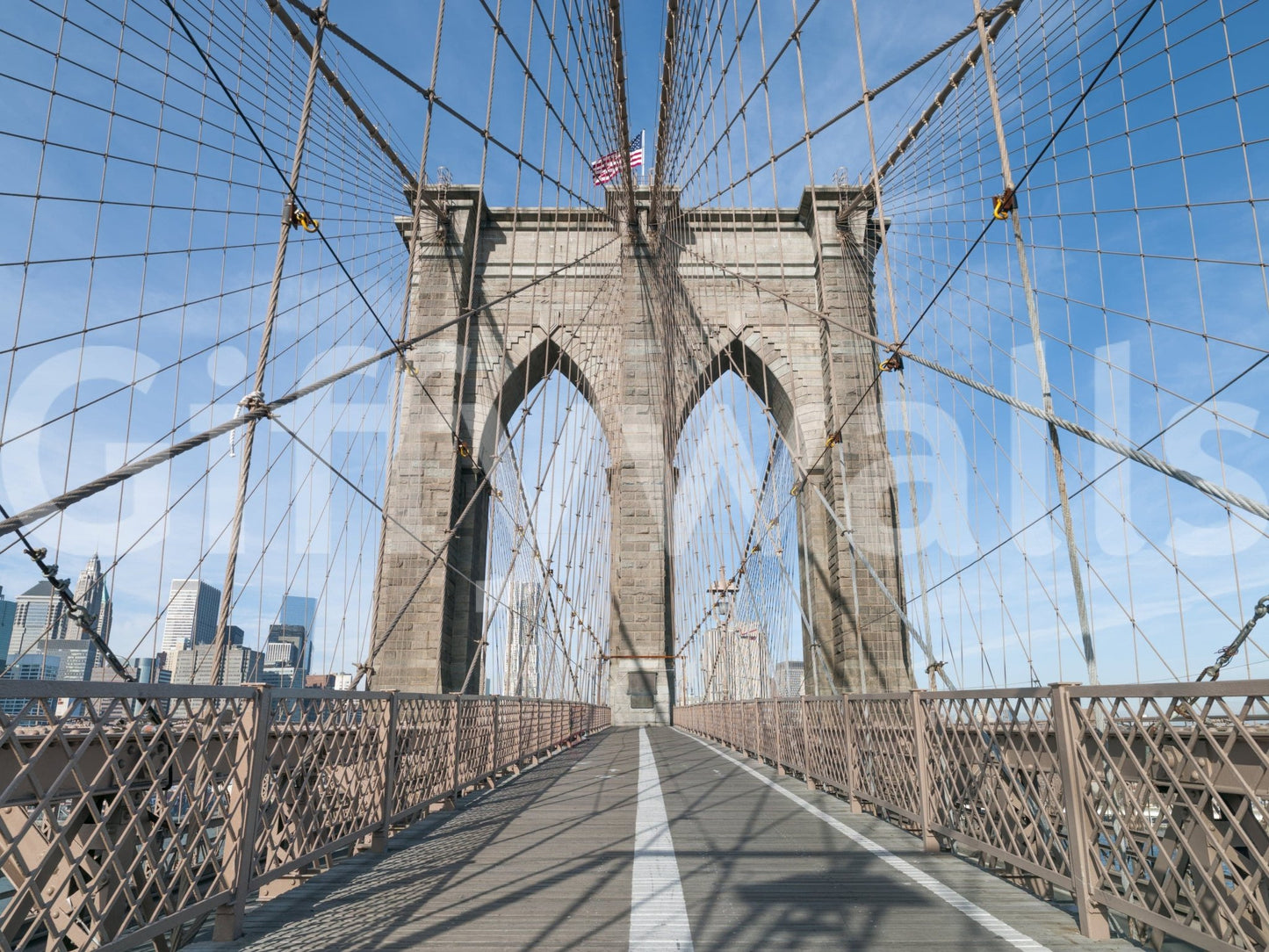 Strolling Across the Brooklyn Bridge wallpaper mural shown as a full-wall render of the walkway, stone tower and US flag