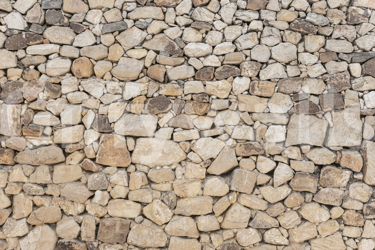 Timeless Stonework wallpaper mural close-up showing tan, cream and grey rounded fieldstone packed in tight mortar