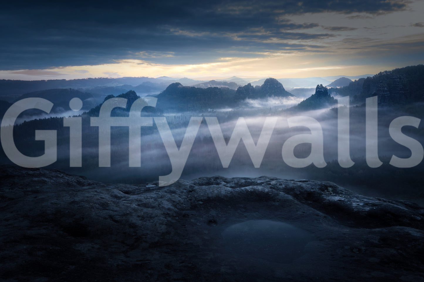 Twilight Mountain Dream wallpaper shown as a full-wall mural of misty blue mountain peaks rising above low fog at dusk