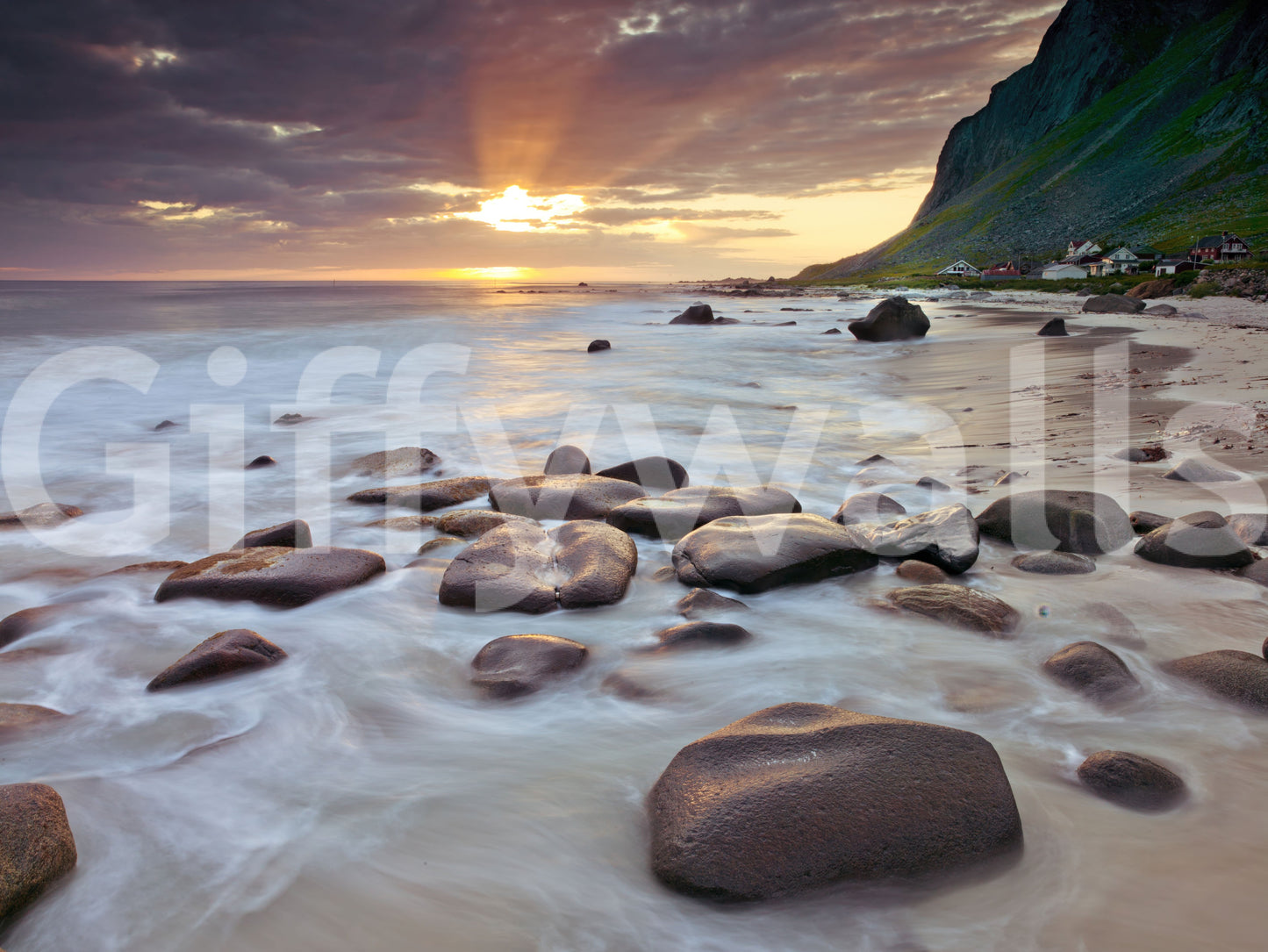 A green headland and shore cottages edge this coastal sunset wall mural