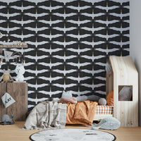 Graceful spoonbills flying across muted gray backdrop

