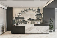 A black-and-white view of London’s Ferris wheel behind historic buildings.

