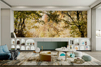 The ground is covered in golden and orange fallen leaves.

