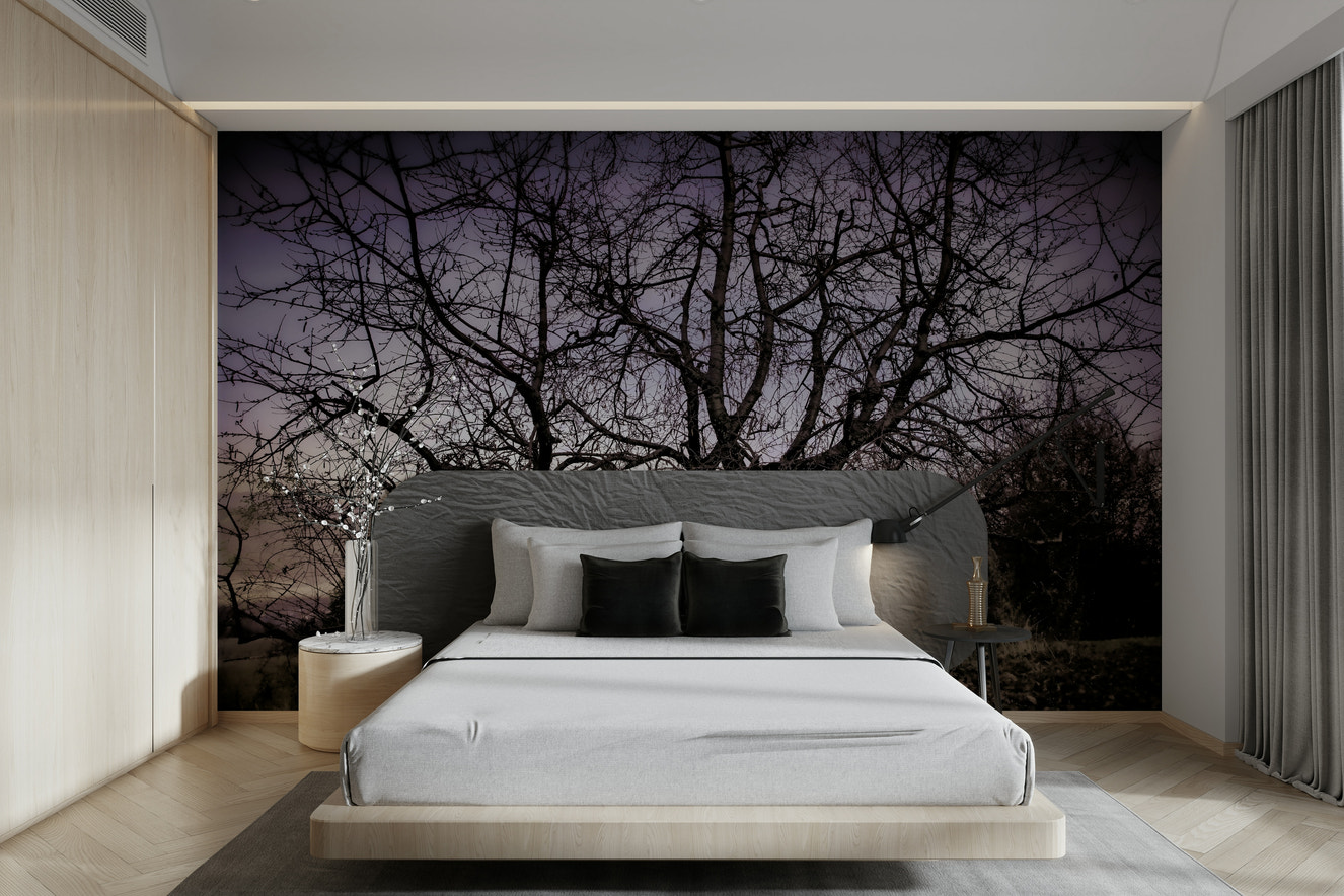 A black-and-white wall mural of a twisted, barren tree silhouette.
