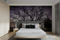 A black-and-white wall mural of a twisted, barren tree silhouette.
