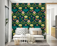 Stylized floral and leaf patterns in rainbow colors on a dark green wall.

