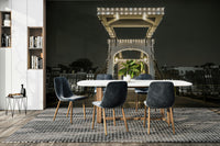 The image shows a classic, white drawbridge illuminated by many small lights.

