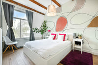 The mural is installed in a calm living room behind a simple, light-colored sofa.

