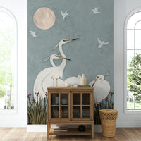 A full-wall mural of a serene night scene with egrets.
