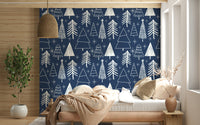 Minimalist tree illustrations and bright stars forming a festive pattern on navy wallpaper.