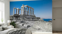 A dramatic wallpaper showing tall temple columns standing firmly atop a rocky landscape by the sea.