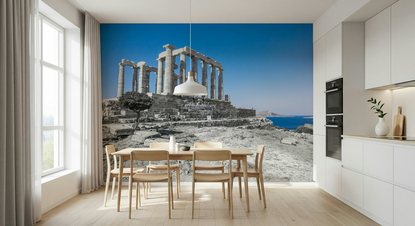 A scenic wallpaper featuring ancient Greek architecture surrounded by rugged stones and deep blue waters.