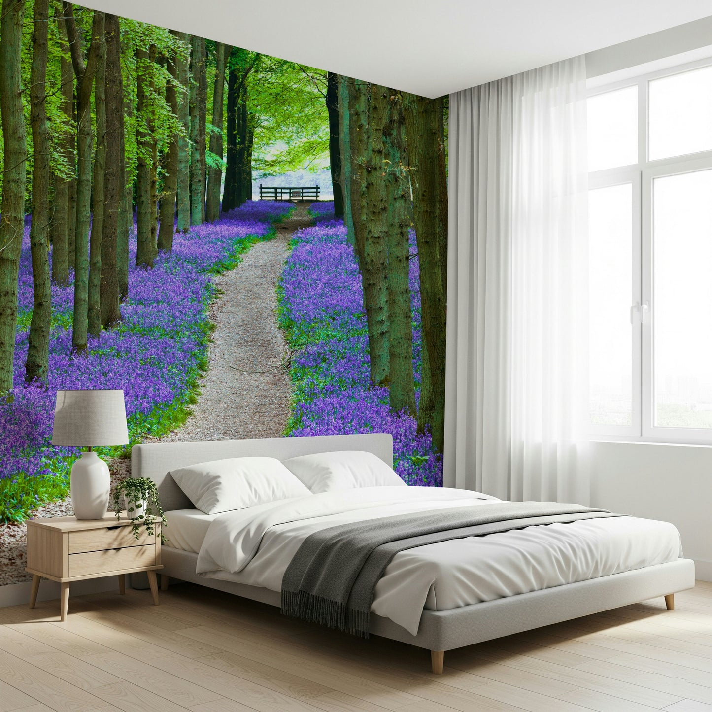 Botanical wallpaper showing a vibrant blanket of bluebells beneath towering green trees.