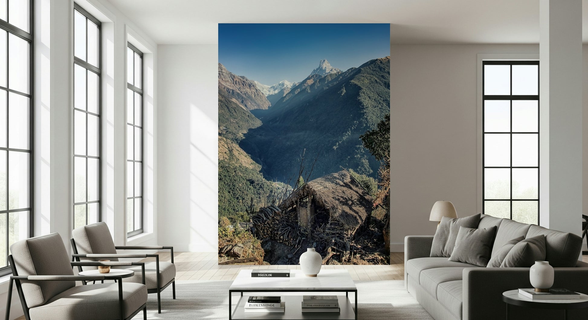 Scenic mountain mural with a thatched hut set against steep forested slopes and distant snow-capped peaks.