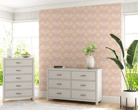 Coastal blush shell wallpaper placed in a soft minimalist living area setting