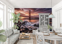 Dining room wall mural featuring ocean waves and bridge under glowing sunset