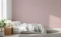 Pastel pink pebble wallpaper spanning this airy bedroom in tonal cream