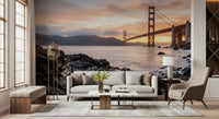 Textured dark rocks fill the foreground of the Golden Gate sunset wall mural scene