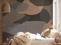 Bedroom feature wall mural in earthy organic layers behind a low neutral bed