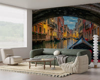 Venice canal wall mural shows a gondola passing beneath a stone bridge arch.