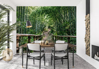 A low timber railing follows the trail in this bamboo forest wall mural.