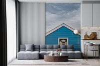 Cloud-filled grey sky frames the Coastal Charm wall mural overhead