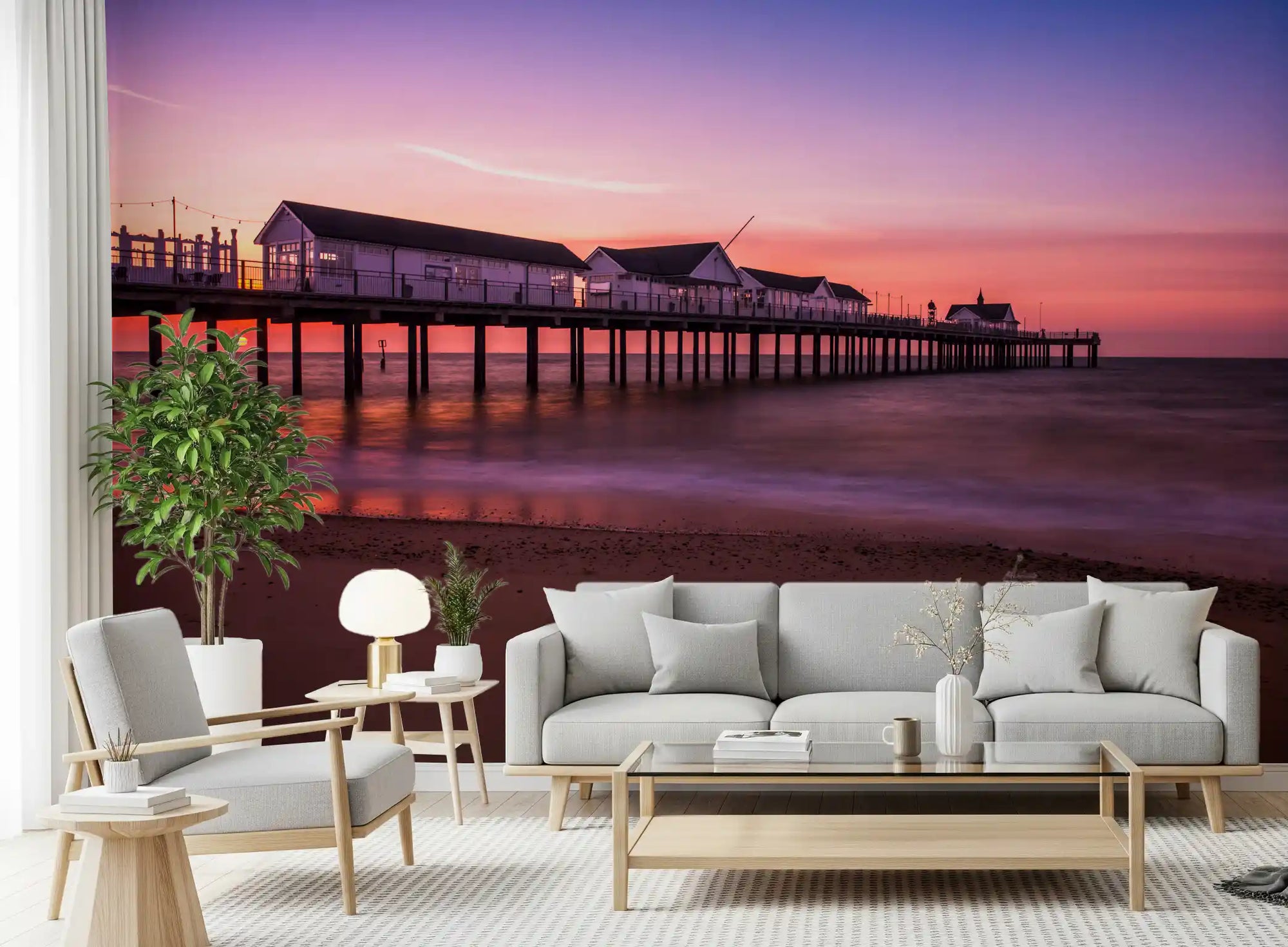 Living room set against the dusky Sunset Pier Reverie wall mural at dusk.
