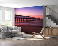 Pink dusk tones warm this living room through the Sunset Pier wall mural.