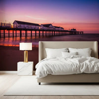 bedroom lit by the gentle violet Sunset Pier Reverie wall mural scene.