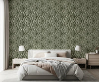 Moss green triangle wallpaper behind a calm bedroom in a boho, earthy scheme