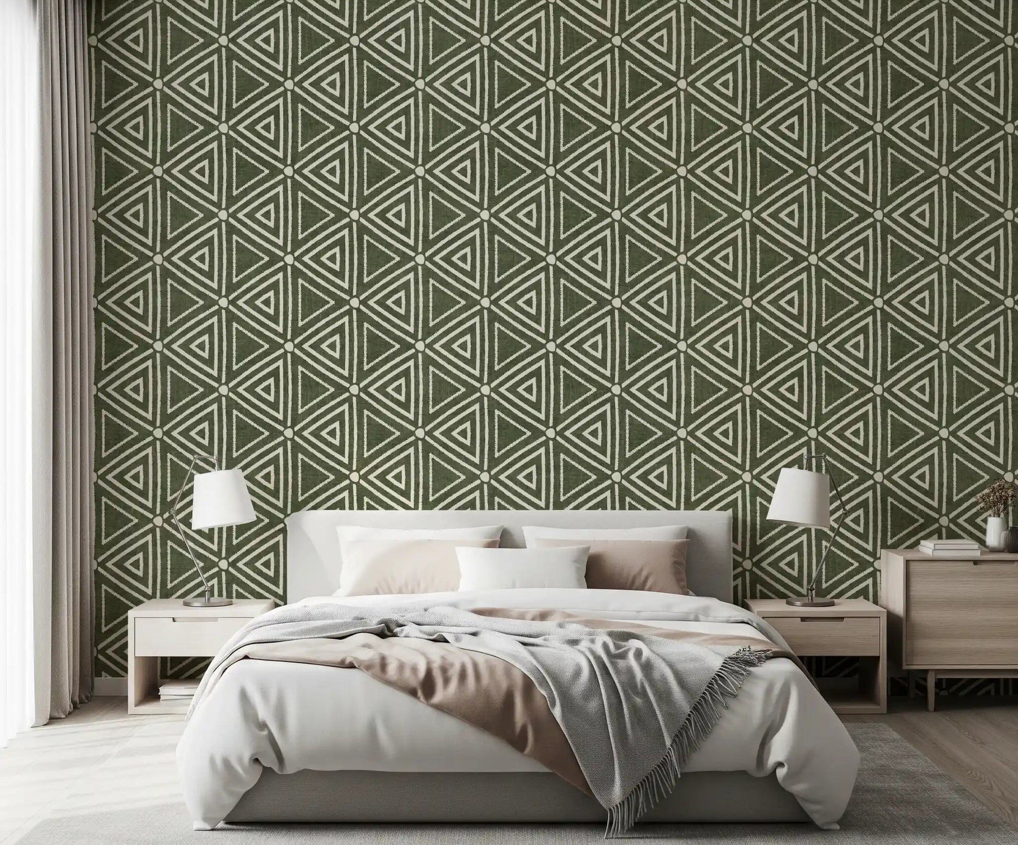 Moss green triangle wallpaper behind a calm bedroom in a boho, earthy scheme
