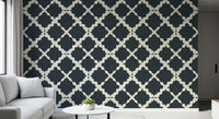 The textured charcoal wallpaper provides deep graphic rhythm for an open living room.