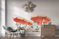 Pale sand extends beneath retro parasols on this coastal wall mural