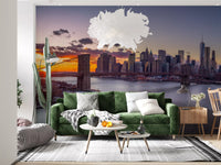 Brooklyn Bridge cables stretch in NYC Sunset Grandeur wall mural beside a lounge setting.