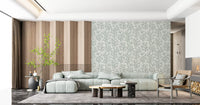Watercolour fronds branch upward in greenish grey on an ivory Coraline wallpaper base