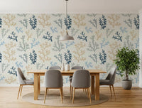 A wooden dining table sits perfectly against the Painted Corals Wallpaper backdrop.