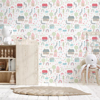 Nursery cot framed by the Baby Village wallpaper in pastel pink and sage tones