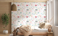 Bedroom corner backed with the Baby Village wallpaper near a tufted pink bench