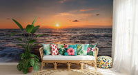 Living area framed by a warm sundown ocean wall mural over open water