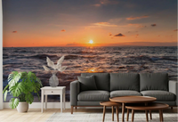 Living room set beneath a glowing Golden Horizon sunset sea wall mural