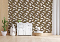 Living room corner backed by repeating golden leopards on this wallpaper