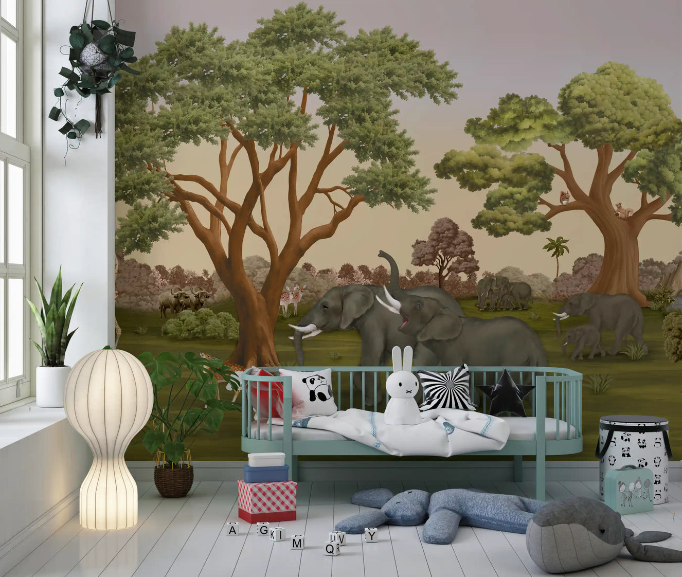 Cosy Nursery area set against roaming elephants and leafy trees wall mural