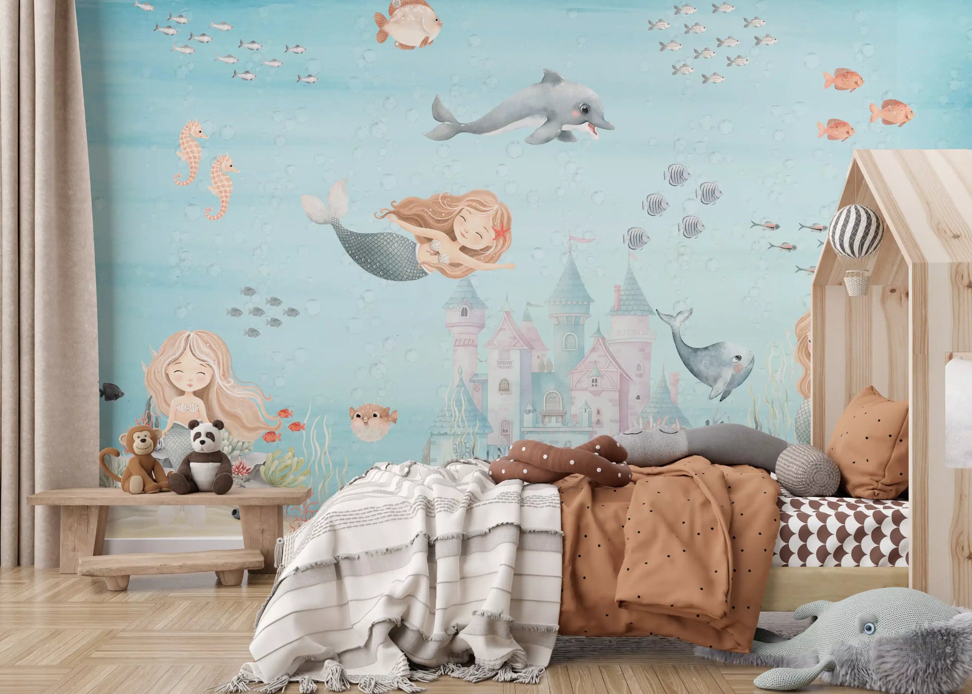 Kids bedroom cot framed by the underwater mermaid scene of this wall mural