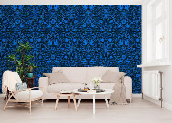 Cobalt folk art wallpaper behind a cream sofa and accent chair with a round table GD12263